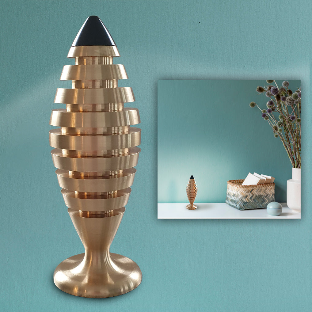 The Tower® aus Messing mit Halbedelsteinen und kleinen Kristallen gefüllt. Im Nahbereich strahlt The Tower® Negativ-Ionen ab für ein gesundes Raumklima mit bis 1.000.000 Bovis. Bei ch.ambition.life bestellen.